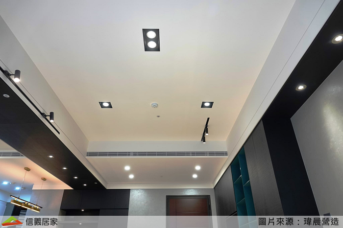 格局規劃上為了揉合場域界限,並未在地板刻畫出明顯區隔,我們利用巧思將大樑下方貼上櫃體同色的木皮連結客餐廳空間,配合使用吊隱式冷氣,天花板上旁的折線,透過溝縫與線條呈現出優雅的光影變化。