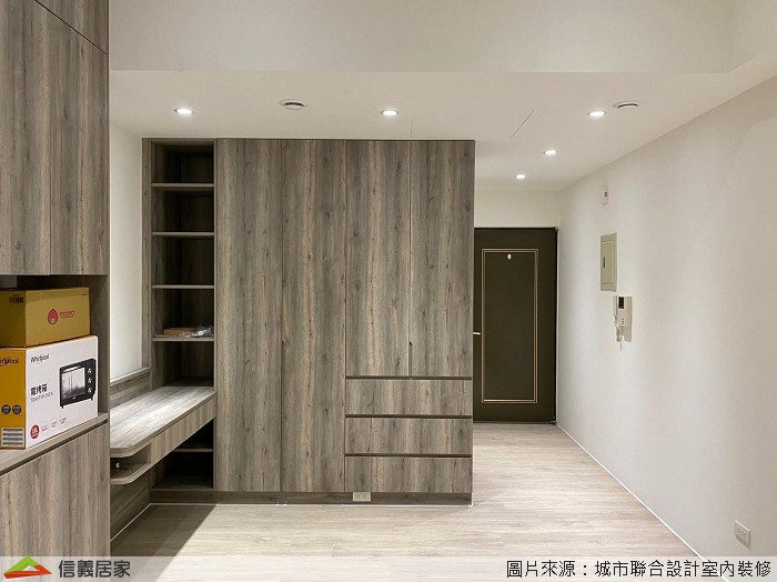 城市工程設計建議，坪數不大的建物應避免過多的色系造成視覺凌亂，簡單白牆設置兩座頂天的系統收納櫃，系統櫃外觀採櫟木皮呈現爽朗乾淨，並在床頭中央取開放的設計，適合睡前置放眼鏡、水杯或書籍等小物，滿足夫妻不同的需求。